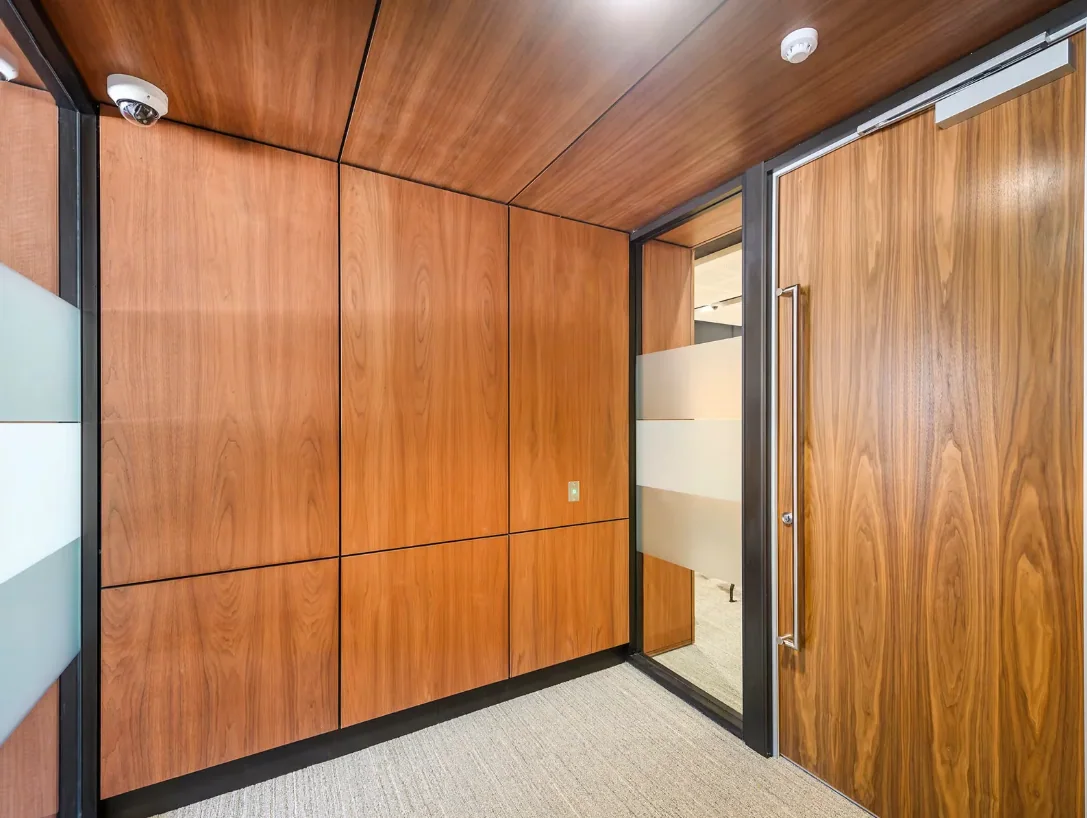 A timber-panelled lobby with a full-height timber door and glazed screen